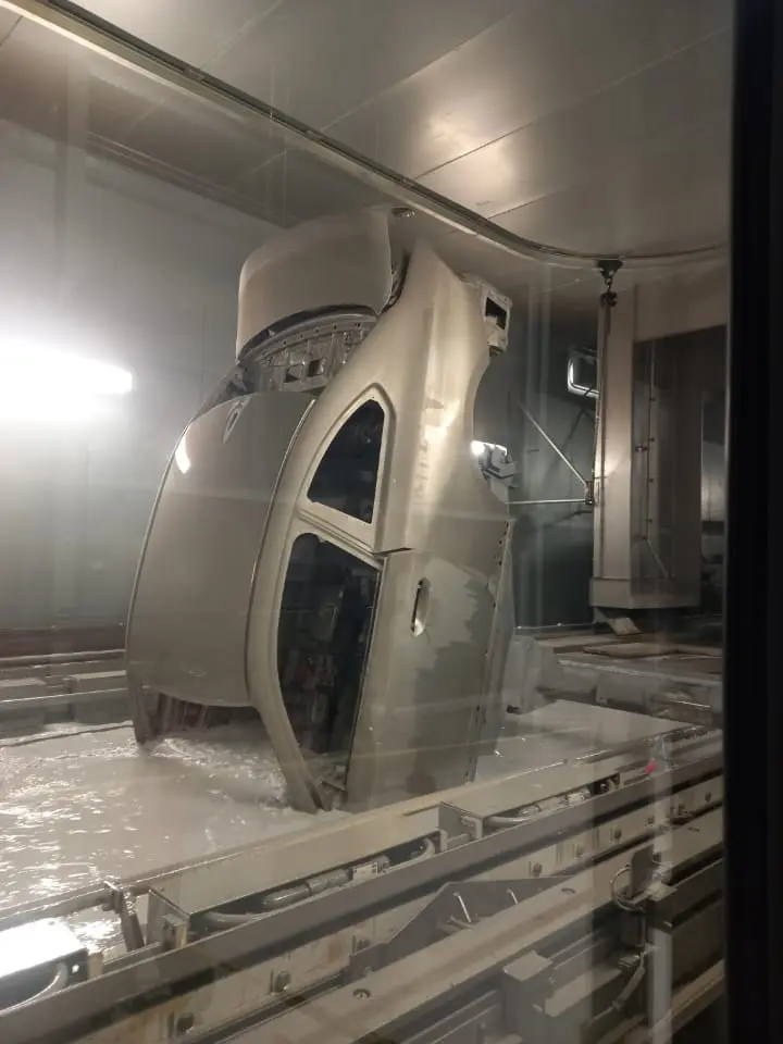 Pieza de carrocería suspendida dentro de una instalación industrial